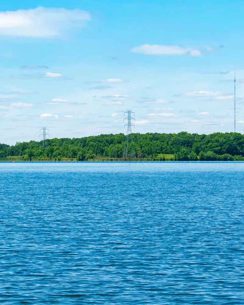 Lake with distant transmission towers under a blue sky